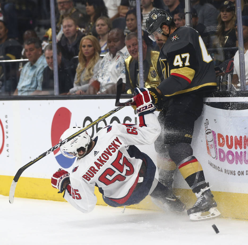 Washington Capitals left wing Andre Burakovsky (65) gets checked by Golden Knights defenseman Luca Sbisa (47) during the second period of Game 1 of the NHL hockey Stanley Cup Final at the T-Mobile ...