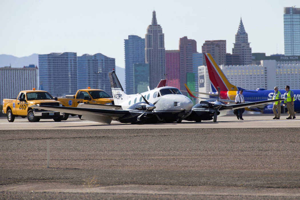 Personnel investigates a small passenger plane on its belly on a runway at McCarran International Airport in Las Vegas on Friday, June 29, 2018. Richard Brian Las Vegas Review-Journal @vegasphotograph
