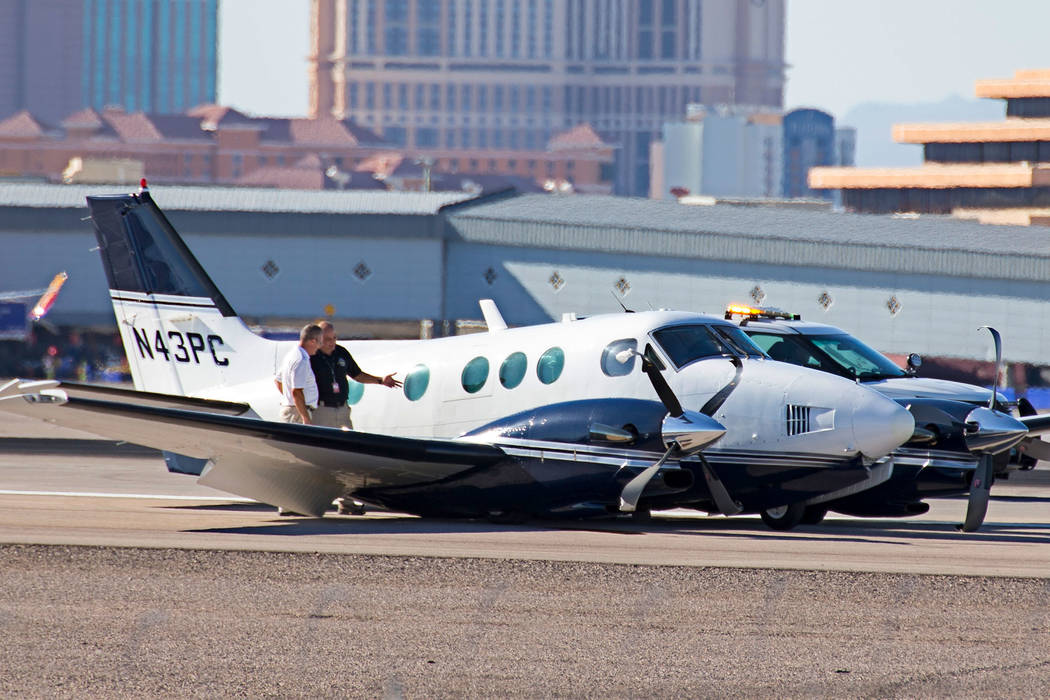 Personnel investigates a small passenger plane on its belly on a runway at McCarran International Airport in Las Vegas on Friday, June 29, 2018. Richard Brian Las Vegas Review-Journal @vegasphotograph