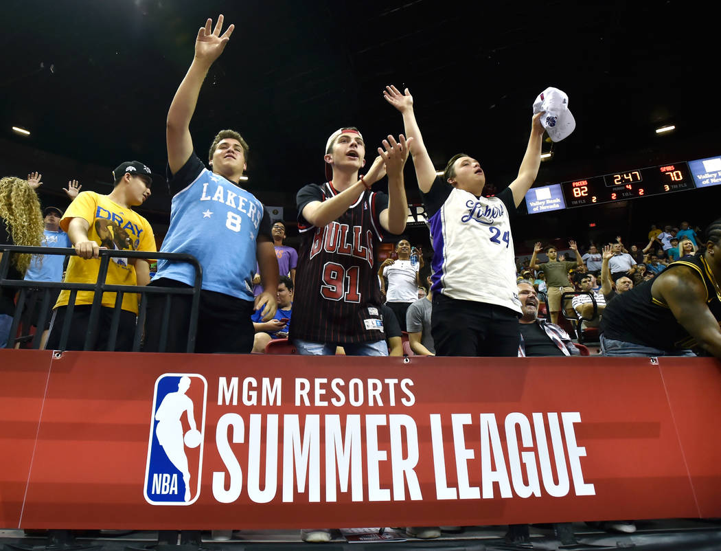 Basketball fans from left, Ayden Matheny, Bill Smith and Chase Matheny cheer during an NBA summer league basketball game between the San Antonio Spurs and Indiana Pacers Saturday, July 7, 2018, in ...