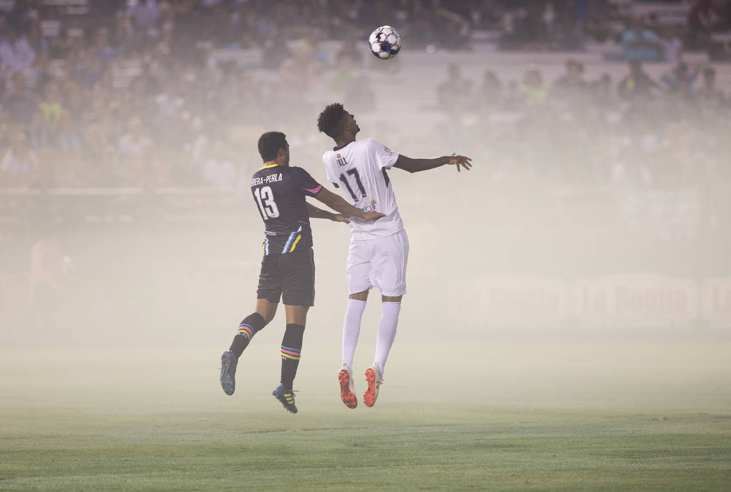Las Vegas Lights FC midfielder Juan Herrera-Perla (13) goes up for a header with Saint Louis FC midfielder Wal Fall (17) in the first half on Saturday, July 7, 2018, at Cashman Field, in Las Vegas ...