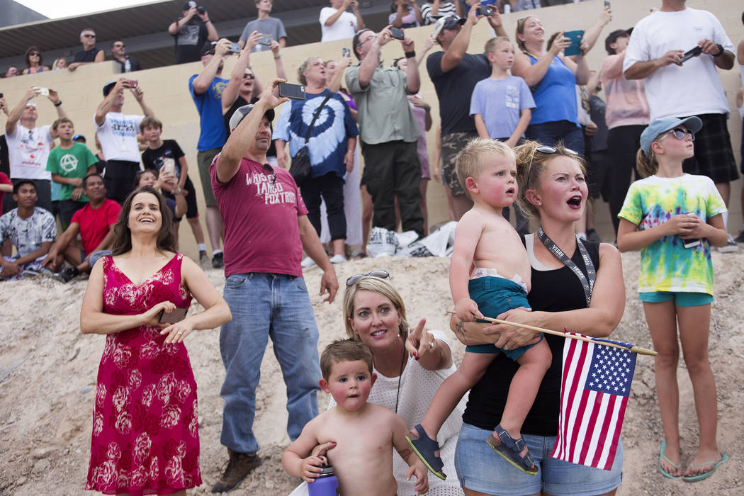 Julie Askim points for her grandson Sawyer Tuck, 4, as Jessica Tuck holds her son Oliver Tuck, 2, as they watch Travis Pastrana jump over 52 crushed cars on an Indian Scout FTR750 motorcycle at th ...