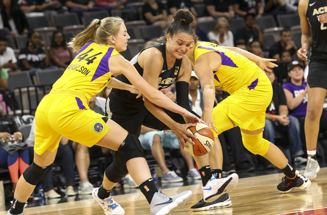 Las Vegas Aces guard Kayla McBride (21), center, attempts to drive the ball through Los Angeles Sparks forward Karlie Samuelson (44) and Sparks center Maria Vadeeva (10) during the second half of ...