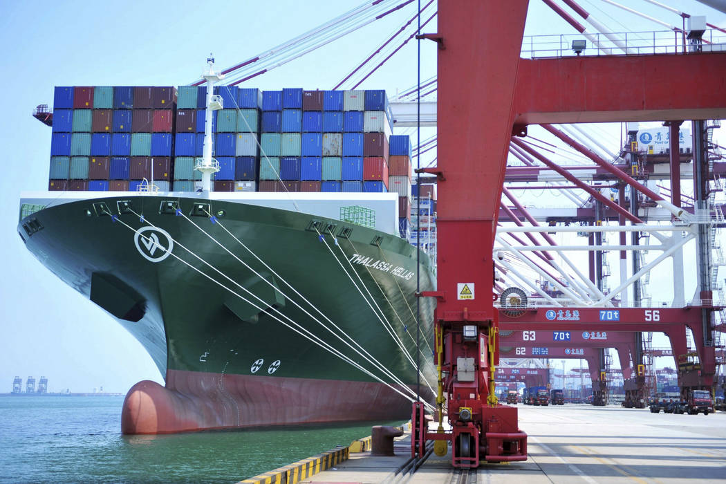 A ship hauls containers at a container port in Qingdao in eastern China's Shandong province Friday, July 6, 2018. The United States hiked tariffs on Chinese imports Friday and Beijing said it imme ...
