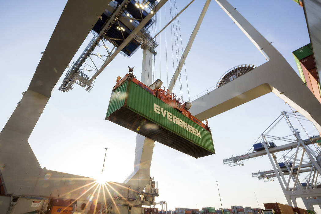 In this June, 19, 2018 photo, a ship to shore crane lifts a 40-foot Evergreen Line shipping container off a jockey truck onto a container ship at the Port of Savannah in Savannah, Ga. The U.S. has ...