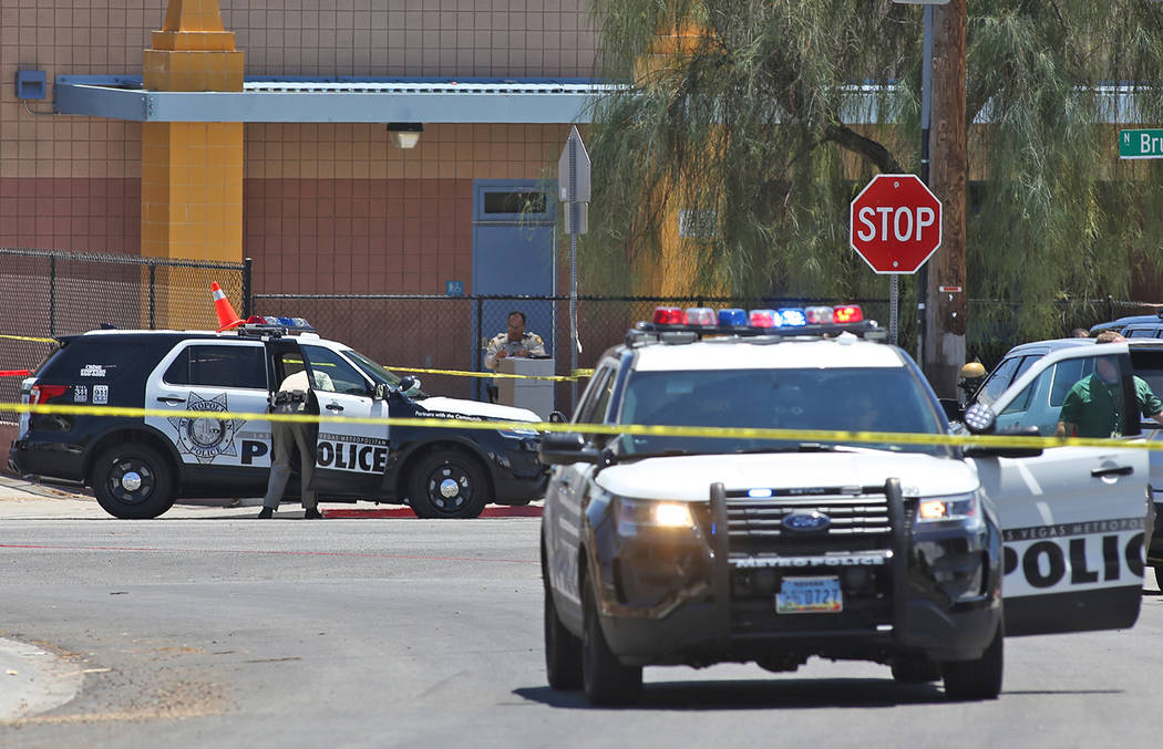 Members of the Metropolitan Police Department near Bruce and Ogden streets after an officer-involved shooting in Las Vegas, Wednesday, July 11, 2018. The school nearby, Hollingsworth Elementary, r ...