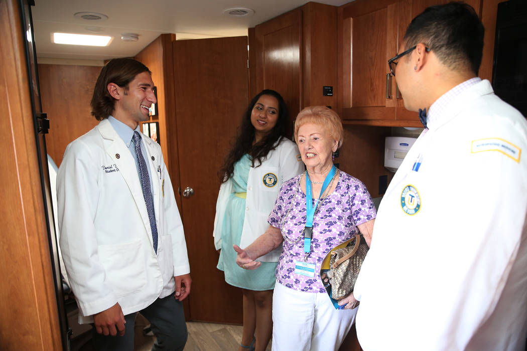 Phillis Christian, third from left, who lives in assisted living in Las Vegas, gets a tour of the new Touro University Nevada mobile healthcare clinic by student doctors from left, Daniel DeMers, ...