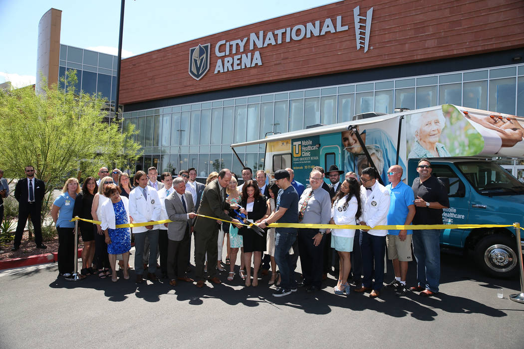 People participate in the ribbon cutting ceremony for the new Touro University Nevada mobile healthcare clinic parked outside at City National Arena in Las Vegas, Thursday, July 19, 2018. Erik Ver ...