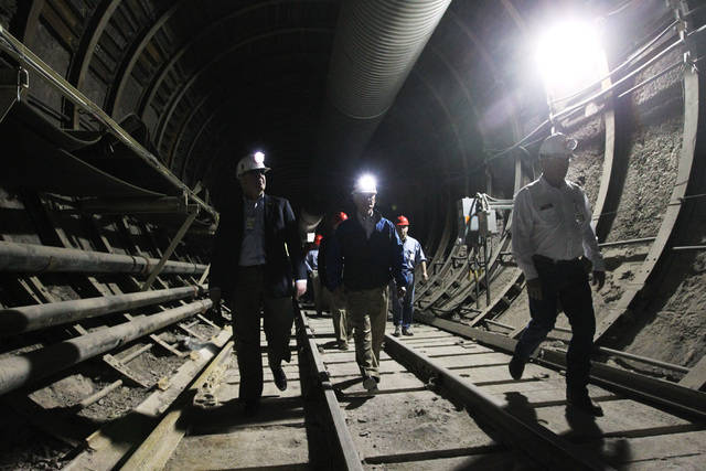 U.S. Rep. John Shimkus, R-Ill., Rep. Bob Latta, R-Ohio and Rep. Cresent Hardy, R-Nev., walk along the train tracks during a congressional tour of the Yucca Mountain exploratory tunnel Thursday, Ap ...