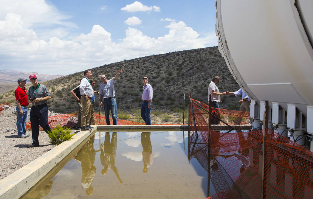 Wiilliam Boyle of the Department of Energy's Office of Nuclear Energy, fourth from left, points to the Yucca Mucker during a congressional tour of Yucca Mountain near Mercury on Saturday, July 14, ...