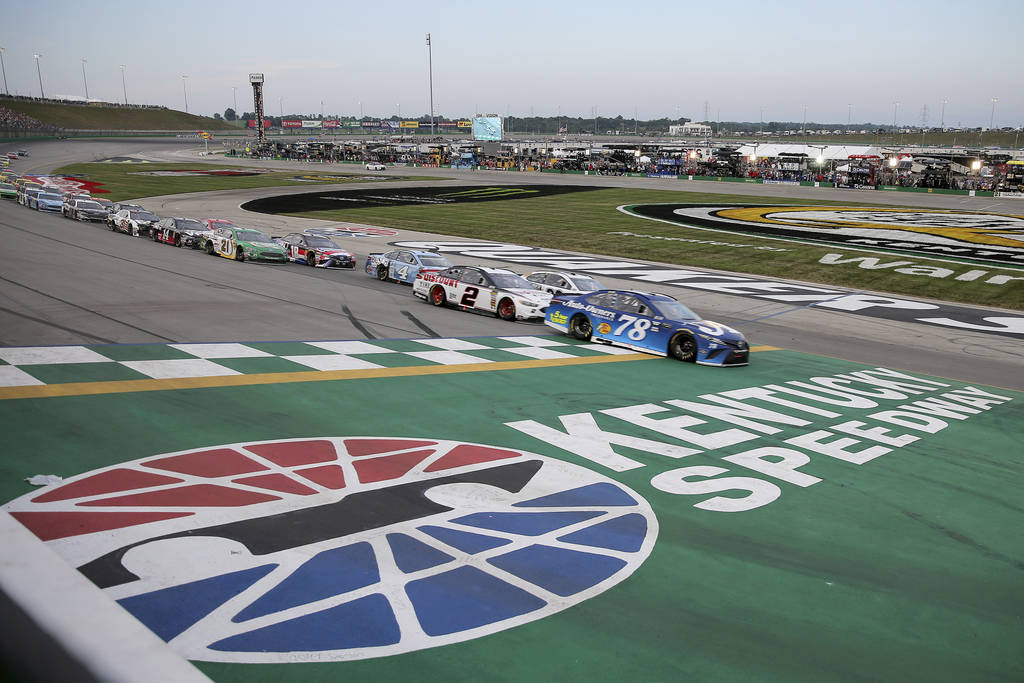 Martin Truex Jr. (78) leads the pack to start the NASCAR Cup Series auto race Saturday, July 14, 2018, at Kentucky Speedway in Sparta, Ky. (Kareem Elgazzar/The Cincinnati Enquirer via AP)