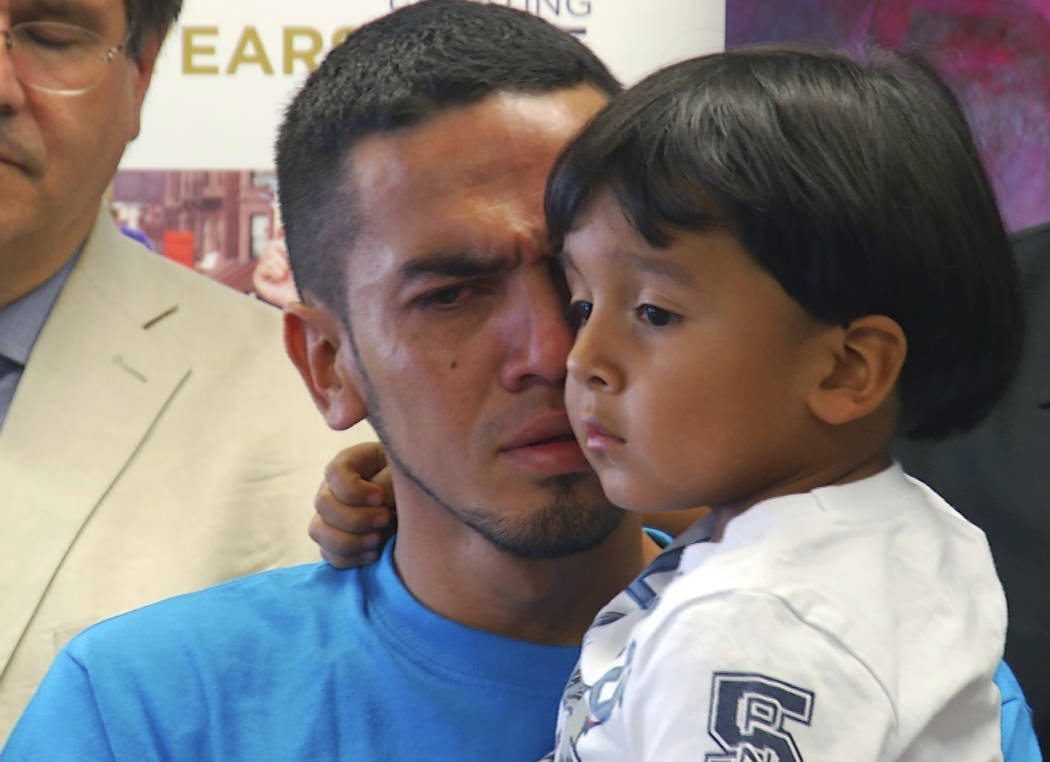 In this image taken from video, Javier Garrido Martinez holds his 4-year-old son during a news conference in New York, Wednesday, July 11, 2018. The pair were reunited after being separated for al ...