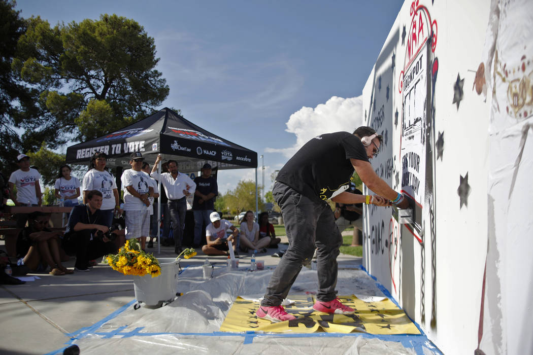 Manny Oliver works on a mural at a Road to Change Voter Registration Walk at Sunset Park in Las Vegas, Monday, July 16, 2018. The event was put on by the March For Our Lives group, created after t ...