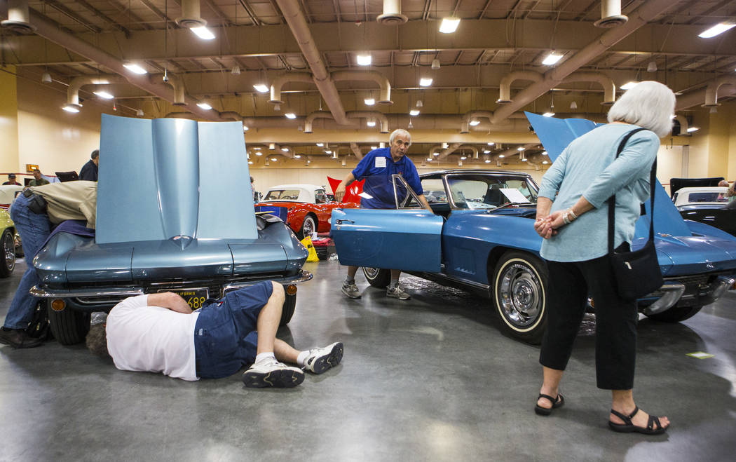 Ray Geiger, center right, checks his 1967 Corvette as a pair of attendees, left, inspect a 1967 Corvette during the National Corvette Restorers Society convention at the South Point in Las Vegas o ...