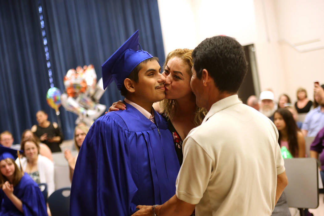 Karla Medina kisses her son Jose Gomez as his dad Jose Gomez watches during a graduation ceremony at Helen J. Stewart School, a special needs school, in Las Vegas, Wednesday, May 16, 2018. Rachel ...