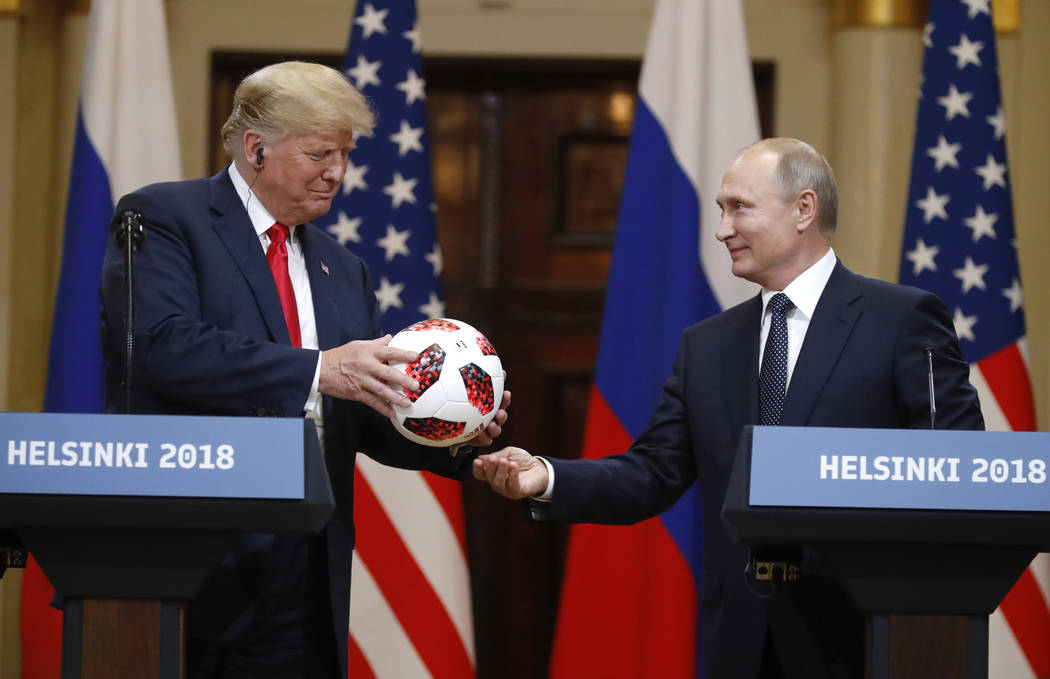 El presidente ruso, Vladimir Putin, le da un balón de fútbol al presidente Donald Trump, izquierda, durante una conferencia de prensa después de su reunión en el Palacio Presidencial en Helsin ...