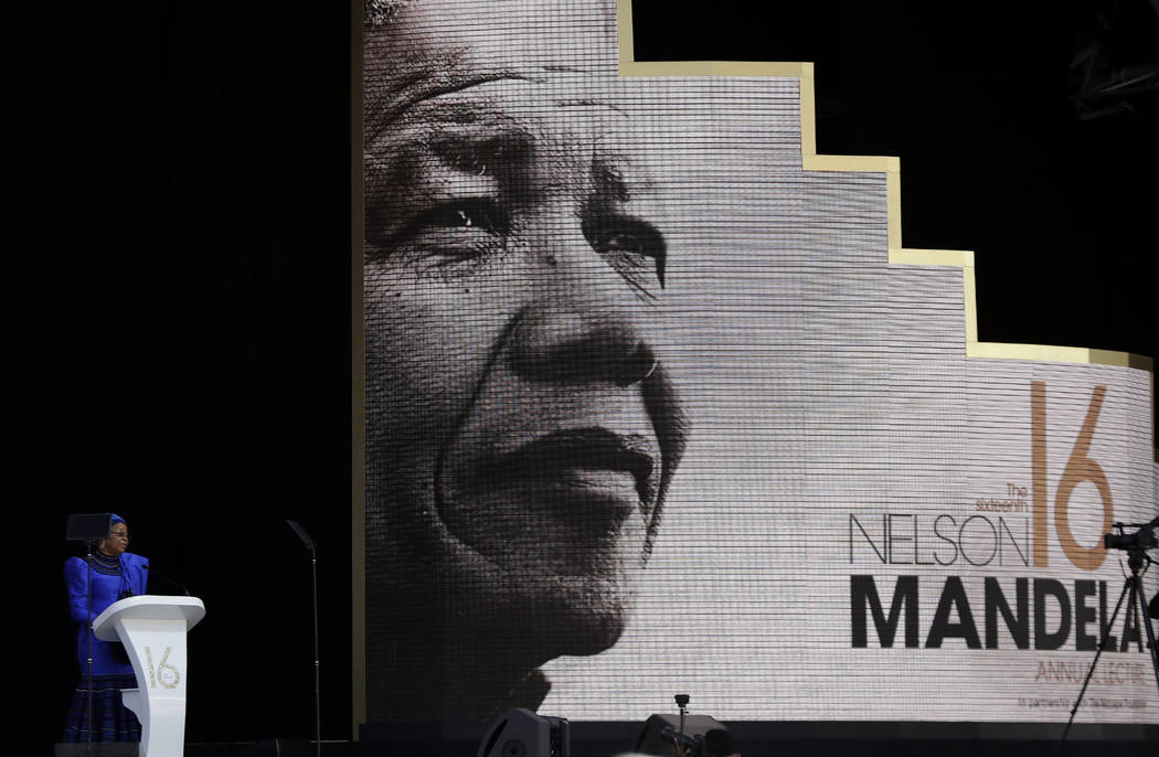 Graca Machel, left, wife of the late Nelson Mandela, background, delivers a speech at the Wanderers Stadium in Johannesburg, South Africa, Tuesday, July 17, 2018 at the 16th Annual Nelson Mandela ...