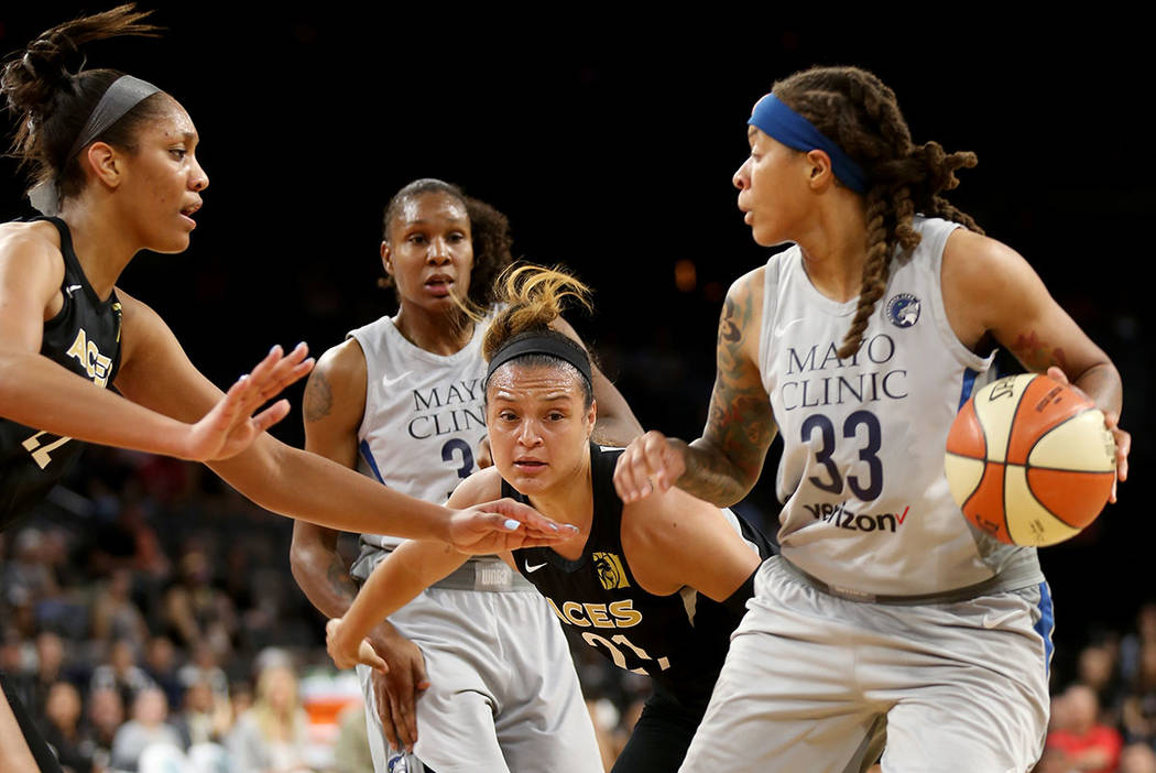 Minnesota Lynx Seimone Augustus (33) attempts to pass the ball past Las Vegas Aces A'ja Wilson (22) and Las Vegas Aces Kayla McBride (21) in the first half of a WNBA basketball game at the Mandala ...