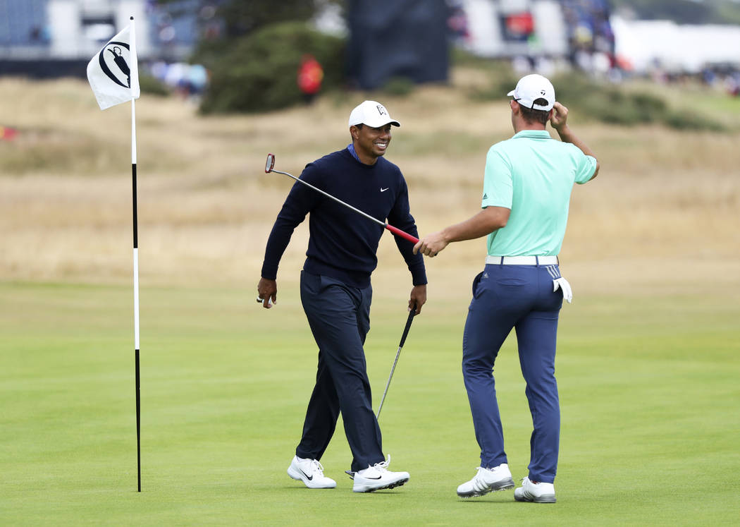 Tiger Woods, left, and Lucas Herbert, of Australia, share a word during a practice round for the 147th British Open Golf championships in Carnoustie, Scotland, Tuesday, July 17, 2018. (AP Photo/Pe ...