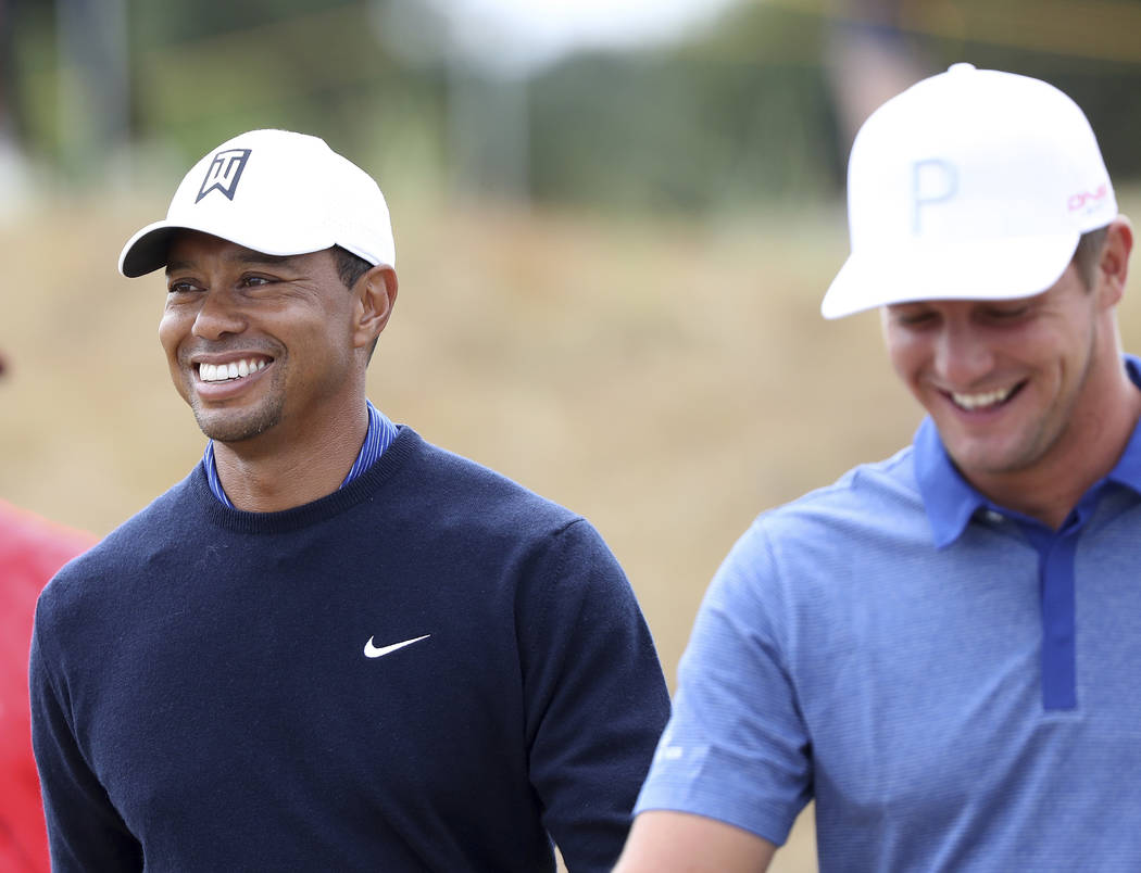 Tiger Woods of the U.S. and Bryson DeChambeau, also of the U.S, smile during a practice round for the 147th British Open Golf championships in Carnoustie, Scotland, Tuesday, July 17, 2018. (AP Pho ...