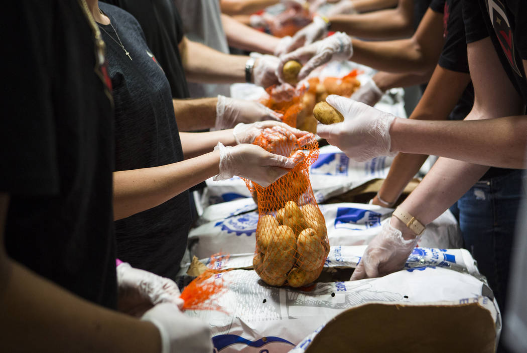 Players and staff of the Las Vegas Aces package potatoes to be part of meal packages for residents in need at the Three Square food bank in Las Vegas on Tuesday, July 17, 2018. Chase Stevens Las V ...