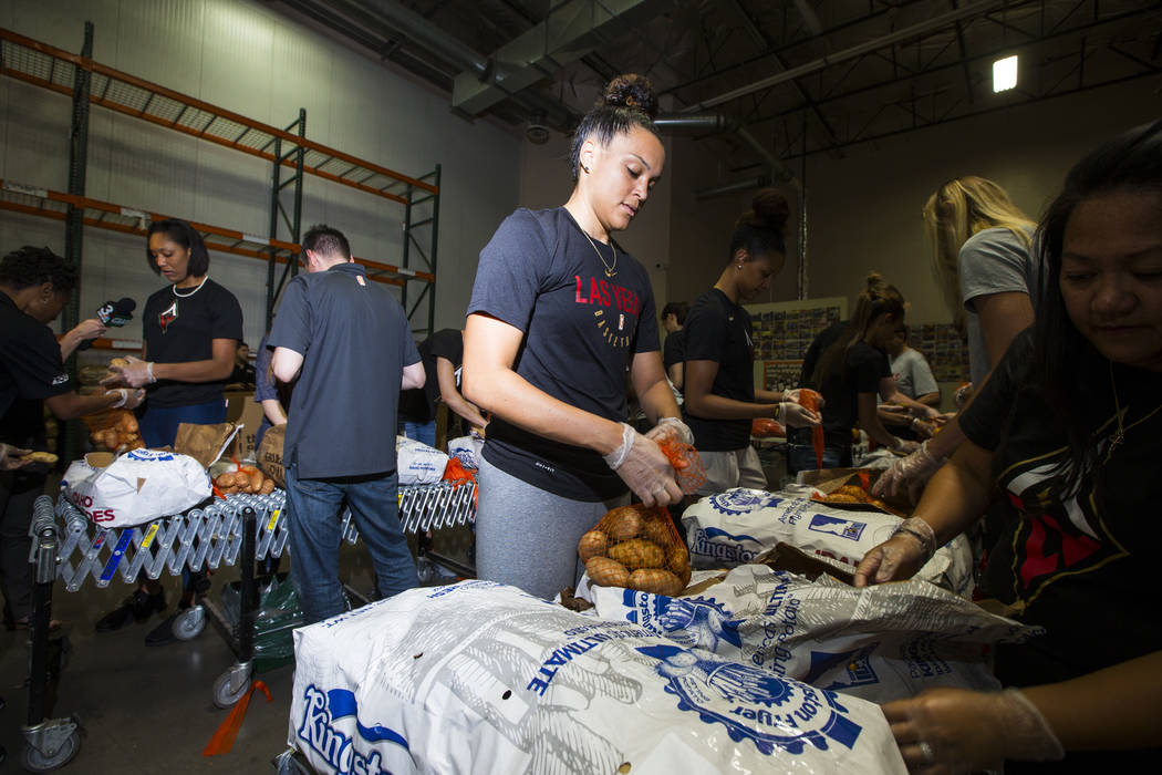 Kayla McBride of the Las Vegas Aces packages potatoes to be part of meal packages for residents in need at the Three Square food bank in Las Vegas on Tuesday, July 17, 2018. Chase Stevens Las Vega ...