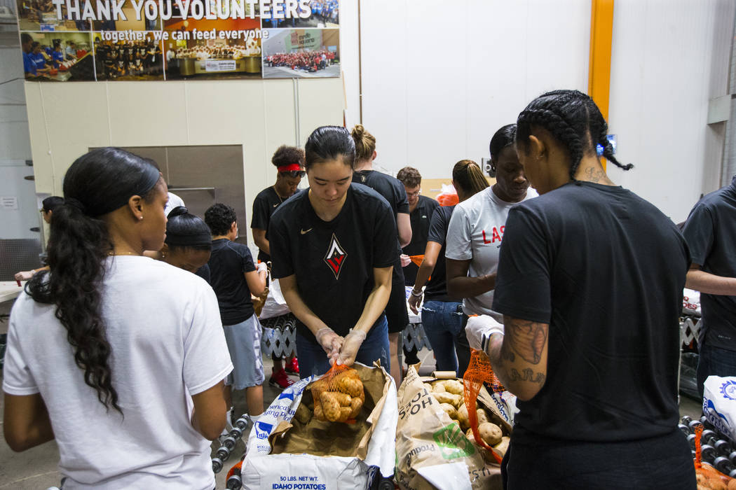 Ji-Su Park of the Las Vegas Aces, center, packages potatoes to be part of meal packages for residents in need at the Three Square food bank in Las Vegas on Tuesday, July 17, 2018. Chase Stevens La ...