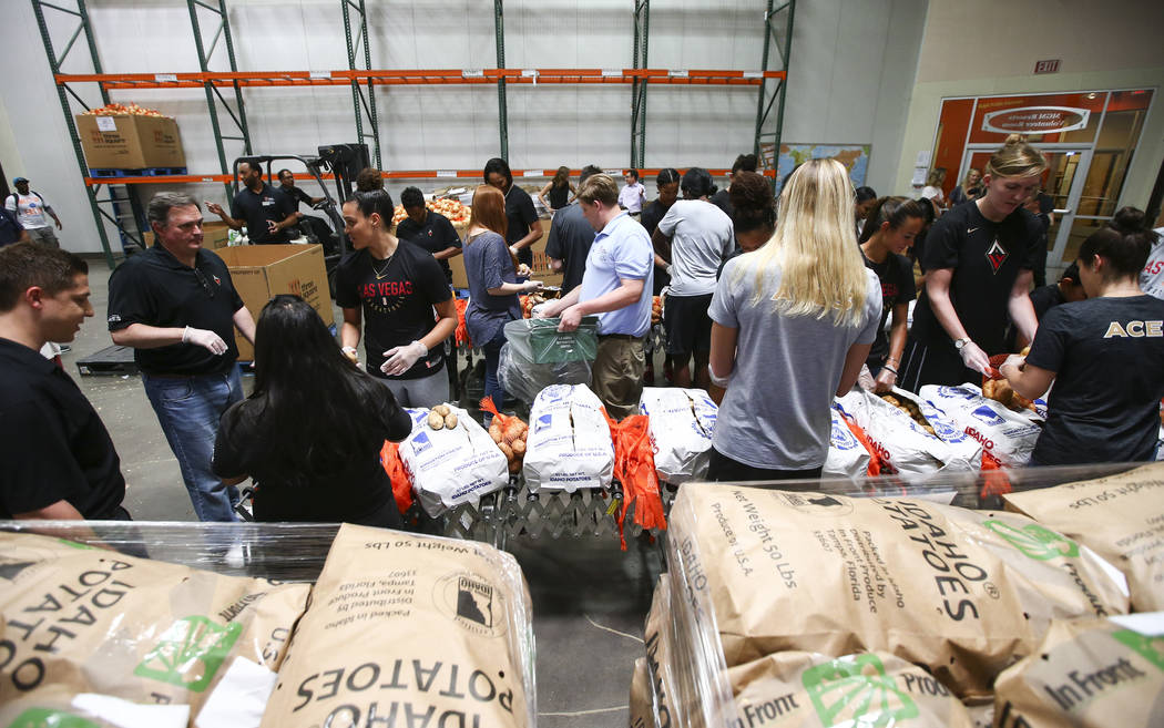 Players and staff of the Las Vegas Aces package potatoes to be part of meal packages for residents in need at the Three Square food bank in Las Vegas on Tuesday, July 17, 2018. Chase Stevens Las V ...