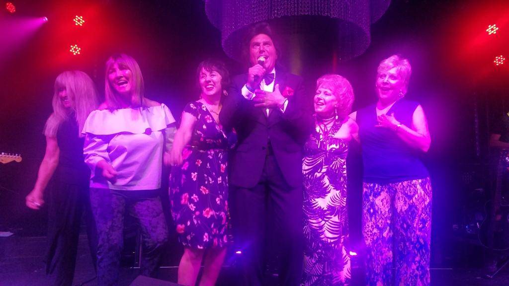 Former Goldiggers, from left, Liz Kelley, Sheila Allan, Patty Booth, Lynn Steiner and Nancy Bonetti are shown with Vinny Adinolfi of the Bronx Wanderers at Bally's on Wednesday, July 11, 2018. (Sa ...