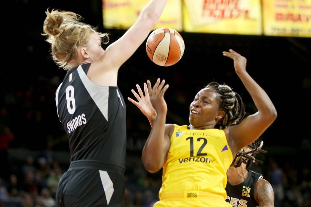 Las Vegas Aces center Carolyn Swords (8) blocks Los Angeles Sparks guard Chelsea Gray (12) during the first half of a WNBA basketball game at the Mandalay Bay Events Center in Las Vegas, Sunday, J ...