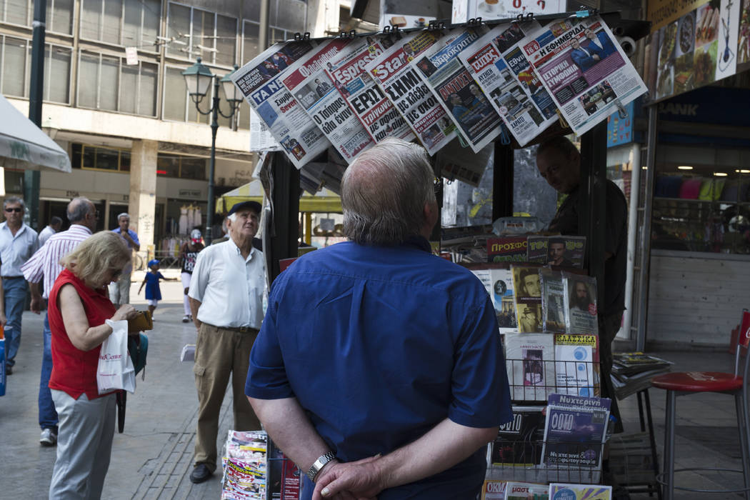 People read newspaper front pages a day after a Greek- Macedonian agreement, at a kiosk in Athens, on Wednesday, June 13, 2018. A historic deal ending a decades-long dispute between neighbors Gree ...