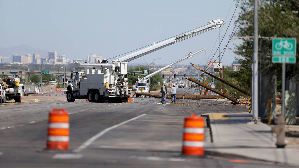 Crews repair fallen power lines on Boulder Highway at Sunset Road, Friday, July 20, 2018, after a late-night thunderstorm brought down power lines between Sunset and Russell roads. (K.M. Cannon/La ...