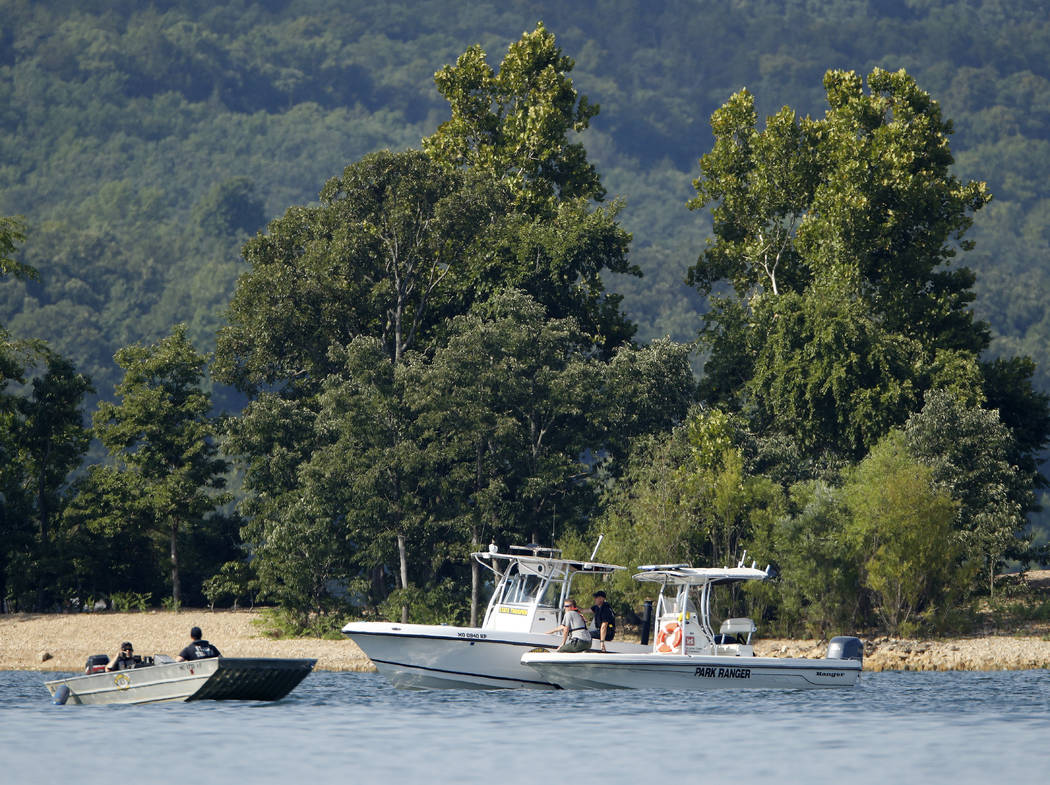 Emergency workers patrol an area Friday, July 20, 2018, near where a duck boat capsized the night before resulting in at least 13 deaths on Table Rock Lake in Branson, Mo. Workers were still searc ...