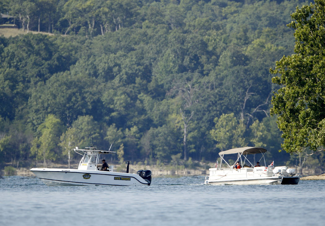 Emergency workers patrol an area Friday, July 20, 2018, near where a duck boat capsized the night before resulting in at least 13 deaths on Table Rock Lake in Branson, Mo. Workers were still searc ...