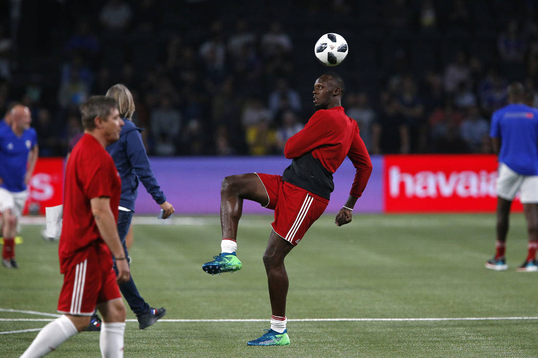 Former Olympic and Jamaican sprinter Usain Bolt controls the ball during a training session prior to the charity soccer match between members of the 1998 World Cup winning French team and a team o ...