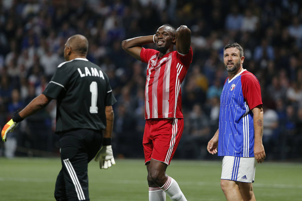 Former Olympic and Jamaican sprinter Usain Bolt, center, reacts during a charity soccer match between members of the 1998 World Cup winning French team and a team of international veteran players ...
