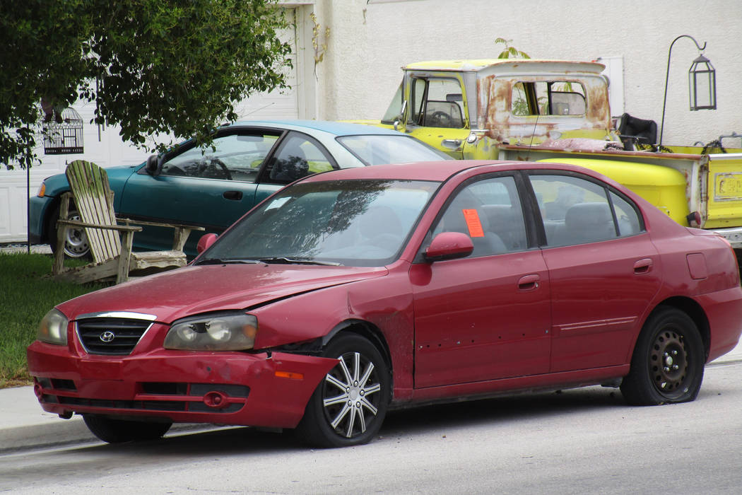A car with a flat tire and a sticker on its driver's side window sits in front of a house in a North Las Vegas neighborhood near Centennial Parkway and Revere Street on Saturday, July 21, 2018. (G ...