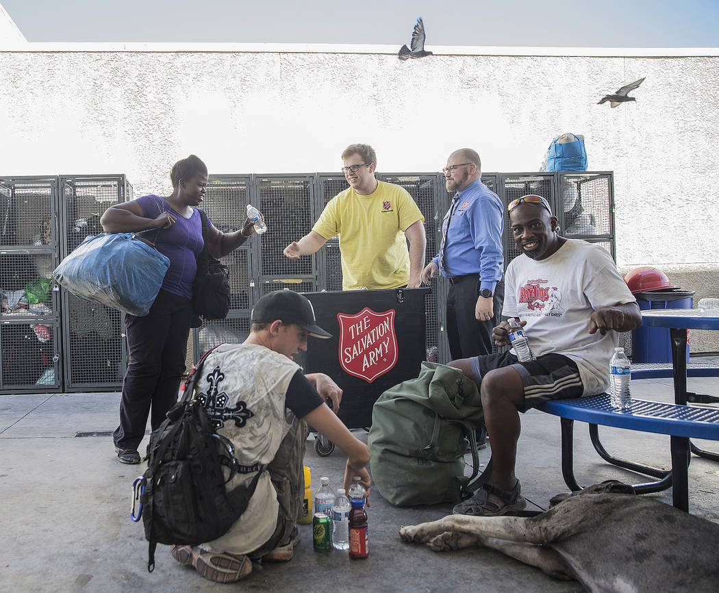 Shelter monitor Boston Brimhall, middle, and homeless services coordinator Ryan McDonald hand out water at a cooling station at The Salvation Army on Thursday, July 5, 2018, in Las Vegas. Benjamin ...