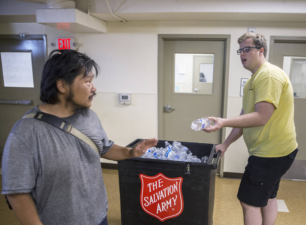 Shelter monitor Boston Brimhall, right, hands out water at a cooling station at The Salvation Army on Thursday, July 5, 2018, in Las Vegas. Benjamin Hager Las Vegas Review-Journal @benjaminhphoto