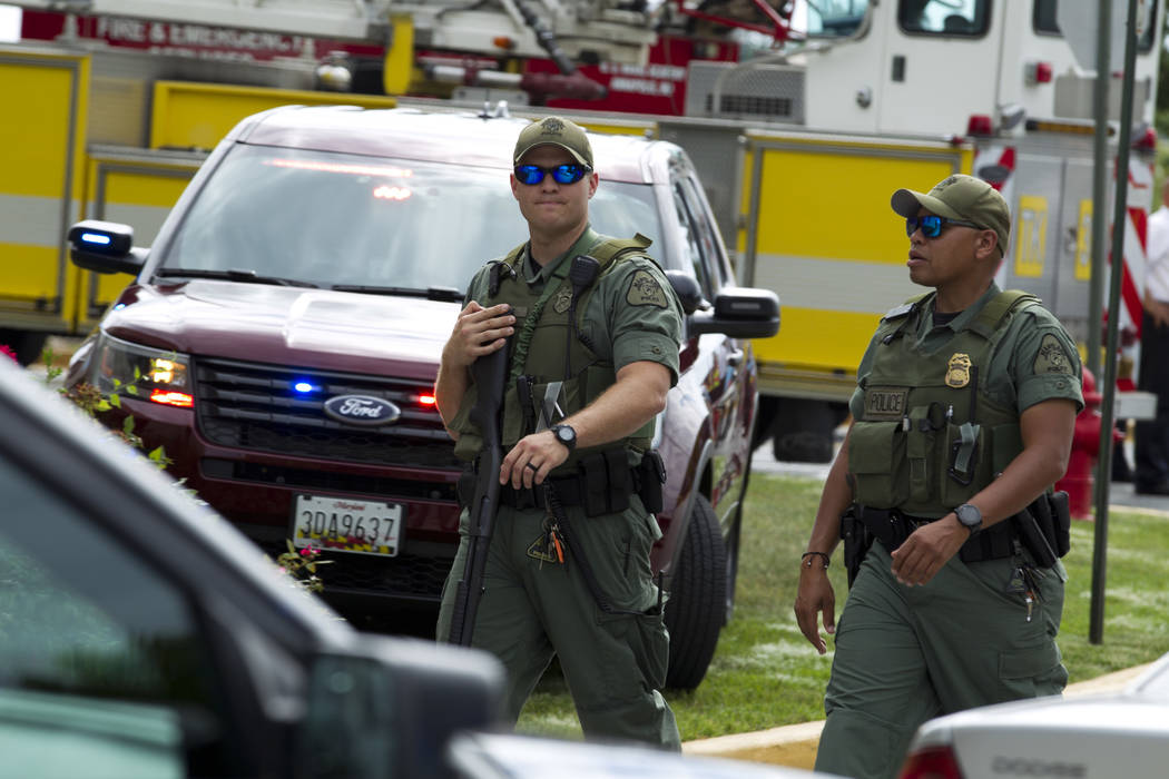 In this June 28, 2018 file photo, Maryland police officers patrol the area after multiple people were shot at at The Capital Gazette newspaper in Annapolis, Md. (AP Photo/Jose Luis Magana, File)