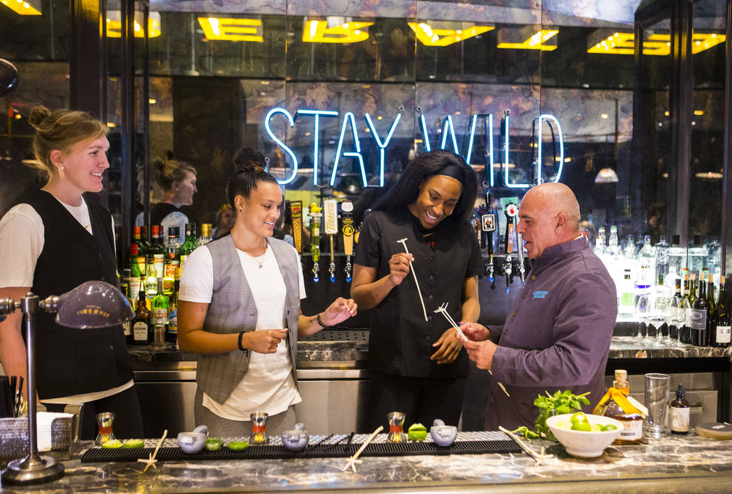 Mixologist Tony Abou-Ganim, right, hands swizzle sticks to Las Vegas Aces players, from left, Carolyn Swords, Kayla McBride and Kelsey Bone at Libertine Social in the Mandalay Bay in Las Vegas on ...