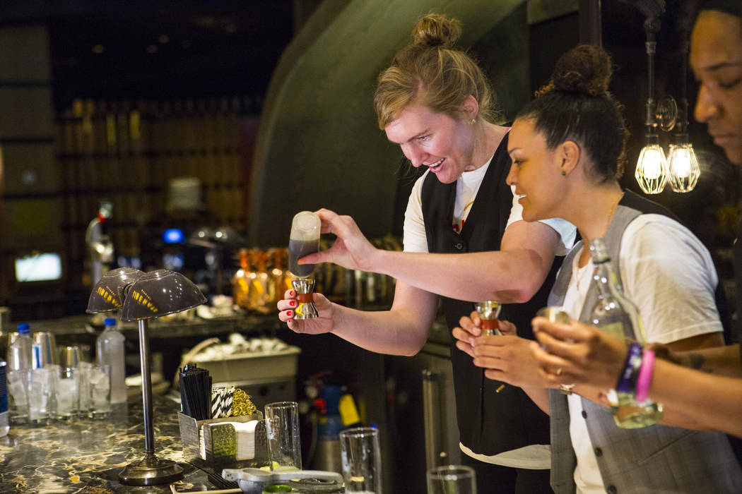 Las Vegas Aces players Carolyn Swords and Kayla McBride make a Summer Swizzle cocktail with the help of mixologist Tony Abou-Ganim. not pictured, at Libertine Social in the Mandalay Bay in Las Veg ...