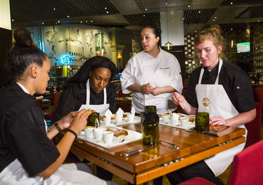 Monica Delgadillo, pastry chef at Stripsteak, third from left, talks with Las Vegas Aces players, from left, Kayla McBride, Kelsey Bone and Carolyn Swords after making beignets in the Mandalay Bay ...
