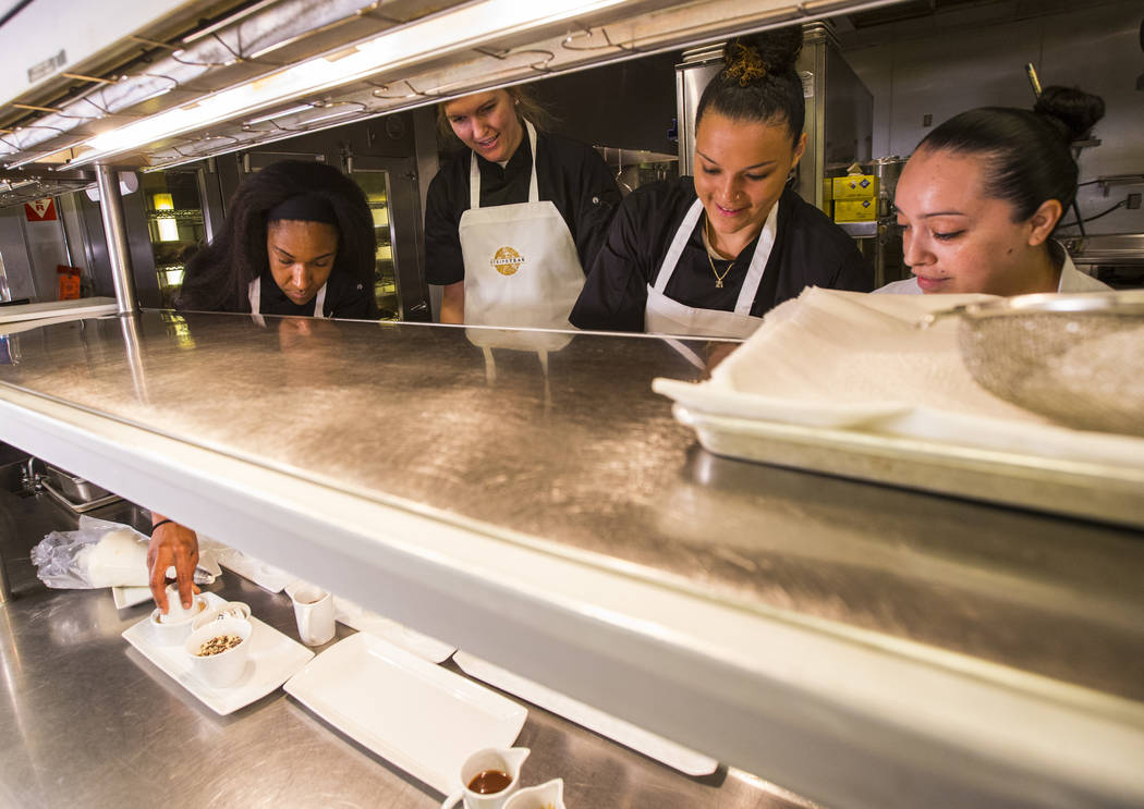 Las Vegas Aces players, from left, Carolyn Swords, Kayla McBride and Kelsey Bone make beignets with the help of Monica Delgadillo, pastry chef at Stripsteak, in the Mandalay Bay in Las Vegas on Sa ...