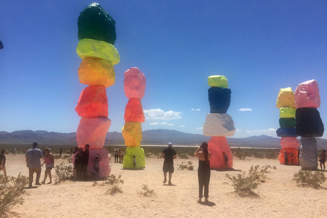 People visit the " Seven Magic Mountains, " art installation located near Jean Dry Lake Bed and Interstate 15 about 10 miles south of Las Vegas, Sunday, July 22, 2018. Swiss artist Ugo Rondinone ...