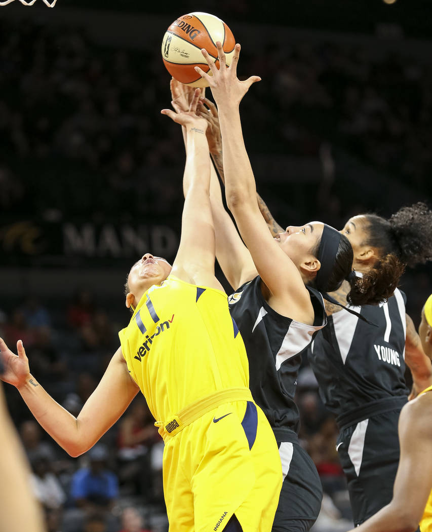 Indiana Fever forward Natalie Achonwa (11), from left, Las Vegas Aces center Ji-Su Park (19) and Aces forward Tamera Young (1) vie for a rebound during the first half of a WNBA basketball game at ...