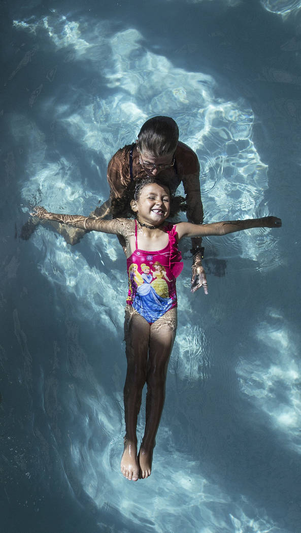 Alynah Lawton, 6, practices floating with the help of water safety instructor Lisa Peschi during swim class at the Hollywood Aquatic Center on Monday, July 23, 2018, in Las Vegas. Benjamin Hager L ...