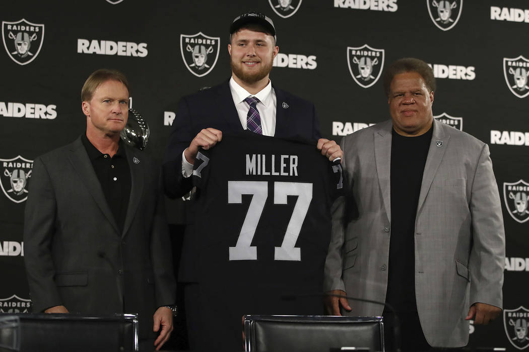 Oakland Raiders draft pick Kolton Miller stands between coach Jon Gruden, left, and General Manager Reggie McKenzie after an NFL football media conference Friday, April 26, 2018, in Alameda, Calif ...