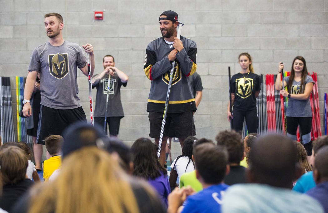 Matt Flynn, senior manager of youth hockey for the Golden Knights, left, and defenseman Deryk Engelland address attendees during a street hockey clinic held by the Golden Knights for local Las Veg ...