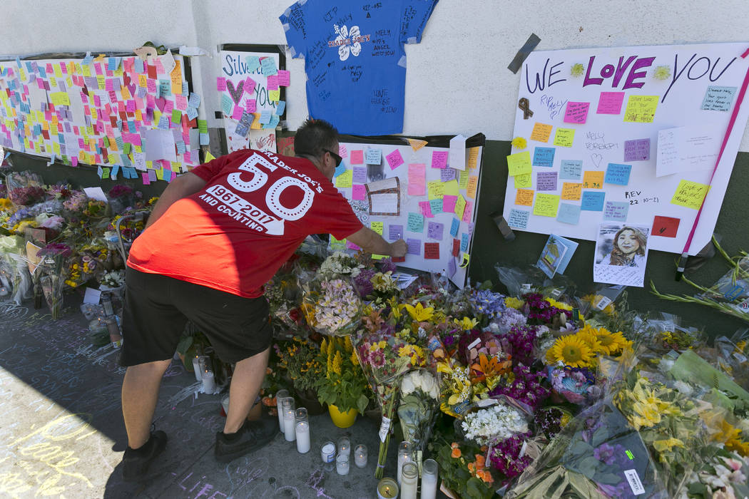 ADDS TO CLARIFY CORADO WAS SHOT TO DEATH IN A GUNFIGHT BETWEEN A GUNMAN AND POLICE - A Trader Joe's employee from the Cerritos, Calif., store posts a message at a makeshift memorial of flowers, ca ...